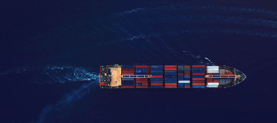 High angle view of cargo ship on the move during sunrise